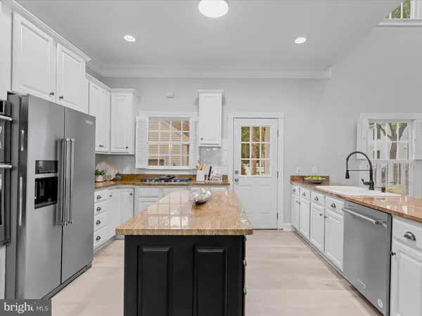 a dining area with furniture a kitchen and chandelier