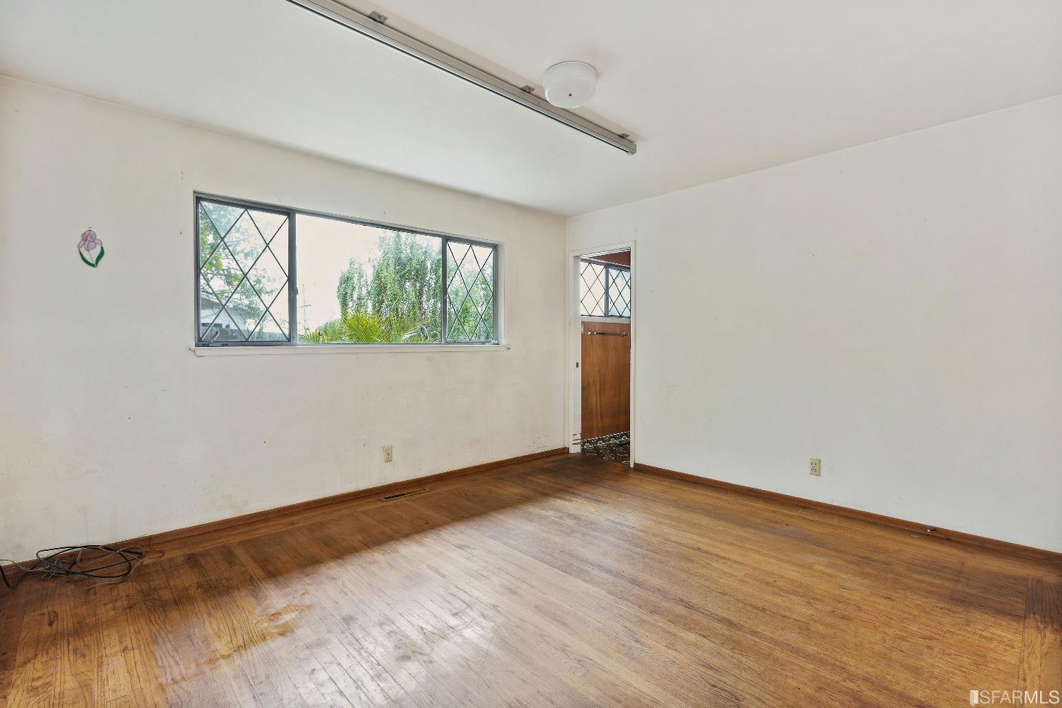 1773 Walnut Street El Cerrito, CA 94530 - Photo 11 of 43 an empty room with wooden floor and windows