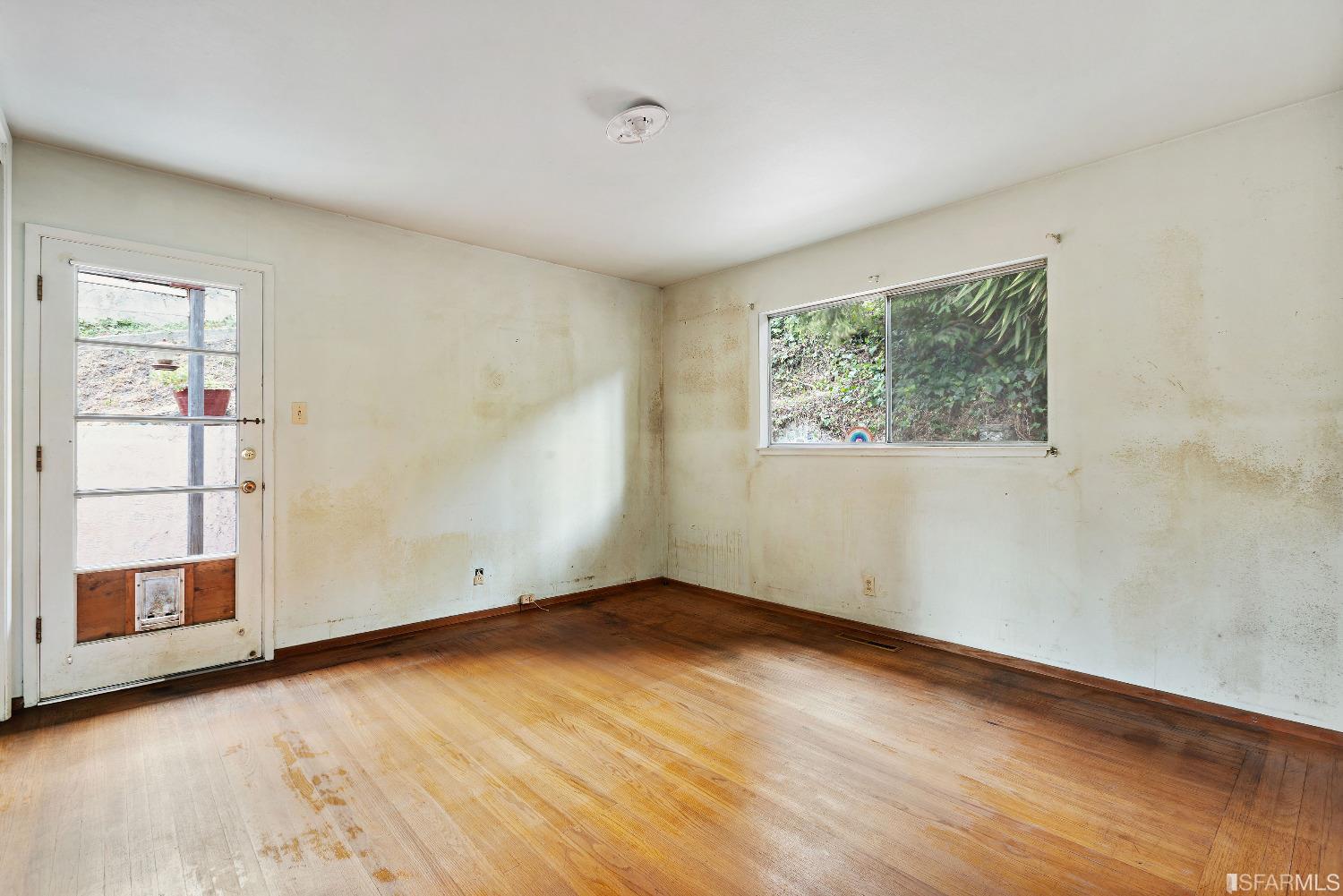 1773 Walnut Street El Cerrito, CA 94530 - Photo 18 of 43 an empty room with wooden floor and windows