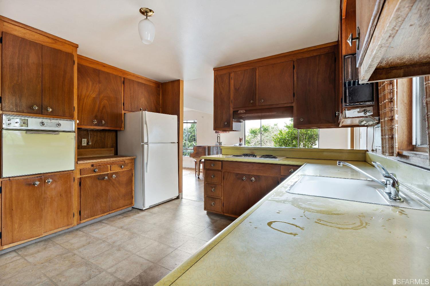 1773 Walnut Street El Cerrito, CA 94530 - Photo 8 of 43 a kitchen with wooden cabinets a refrigerator and a sink