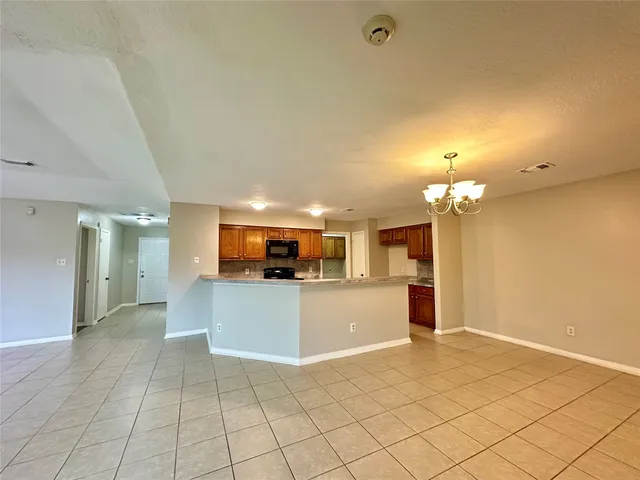 a view of a kitchen with kitchen island stainless steel appliances refrigerator sink and microwave