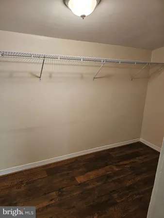 an empty room with wooden floor and a window
