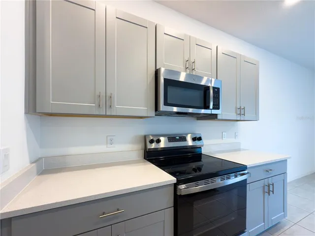 a kitchen with stainless steel appliances granite countertop white cabinets and a stove