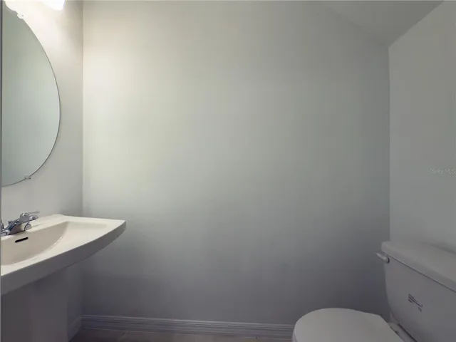a bathroom with a toilet a sink and mirror