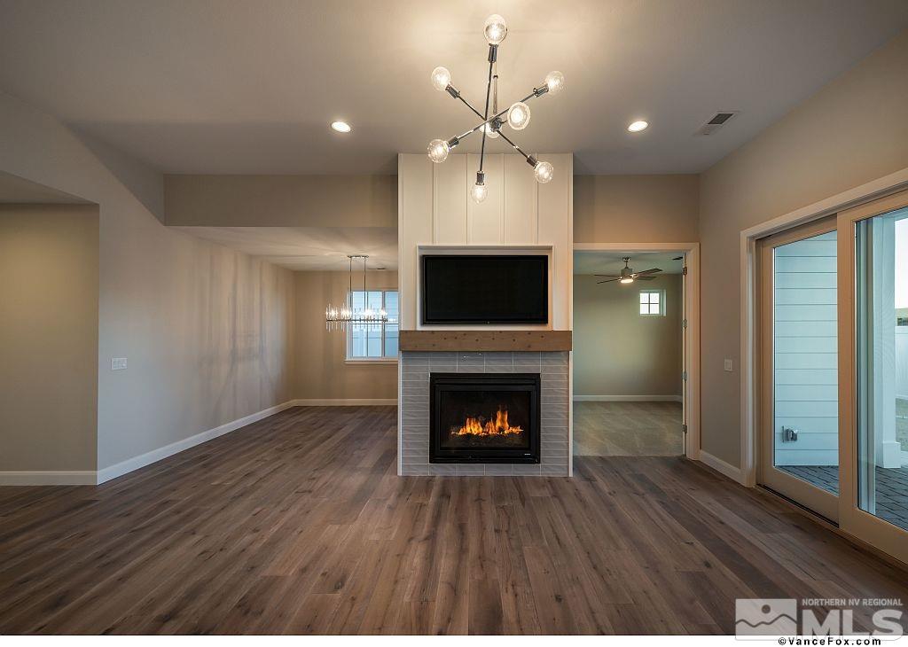 6430 Bonde Lane Reno, NV 89511 - Photo 4 of 9 an empty room with wooden floor fireplace and windows