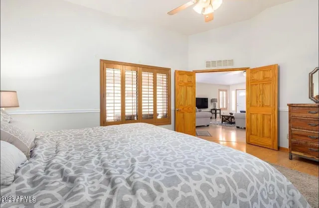 a large bedroom with a large bed and a chandelier