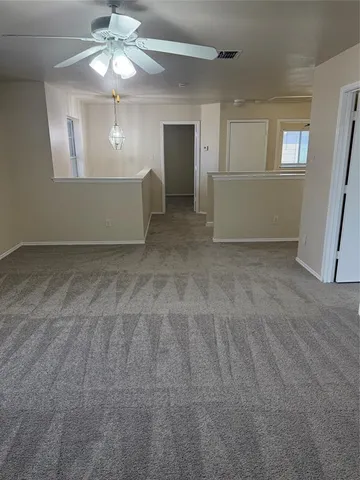 an empty room with a chandelier fan