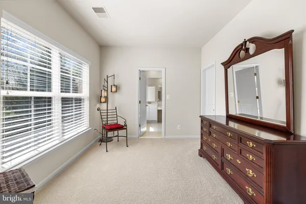 a spacious bedroom with a bed dresser and a window