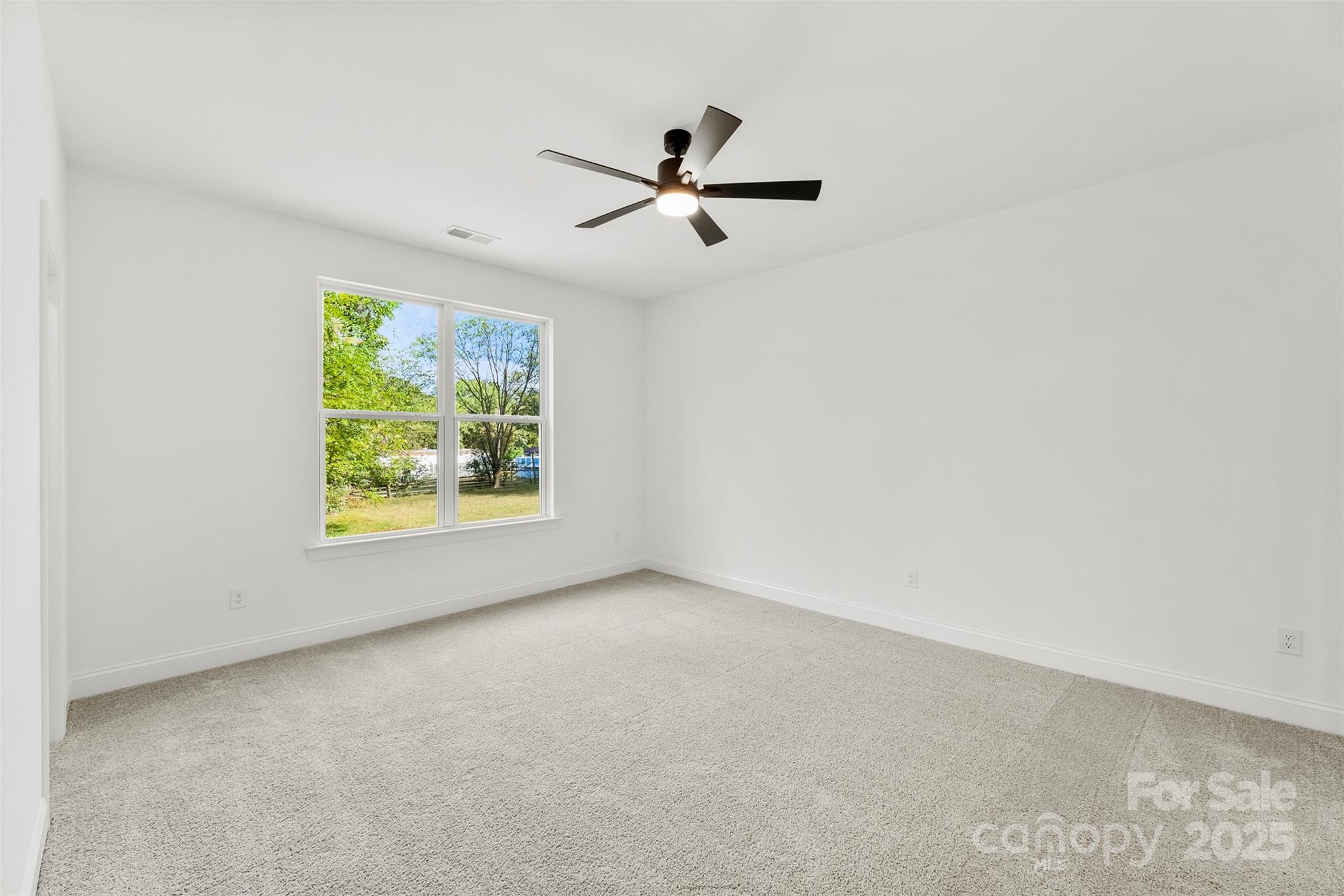 90 Sumner Avenue Northwest Concord, NC 28027 - Photo 15 of 40 an empty room with window and ceiling fan