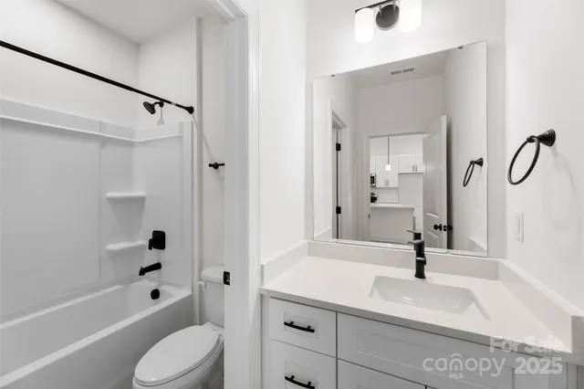 a bathroom with a sink a toilet and a large mirror