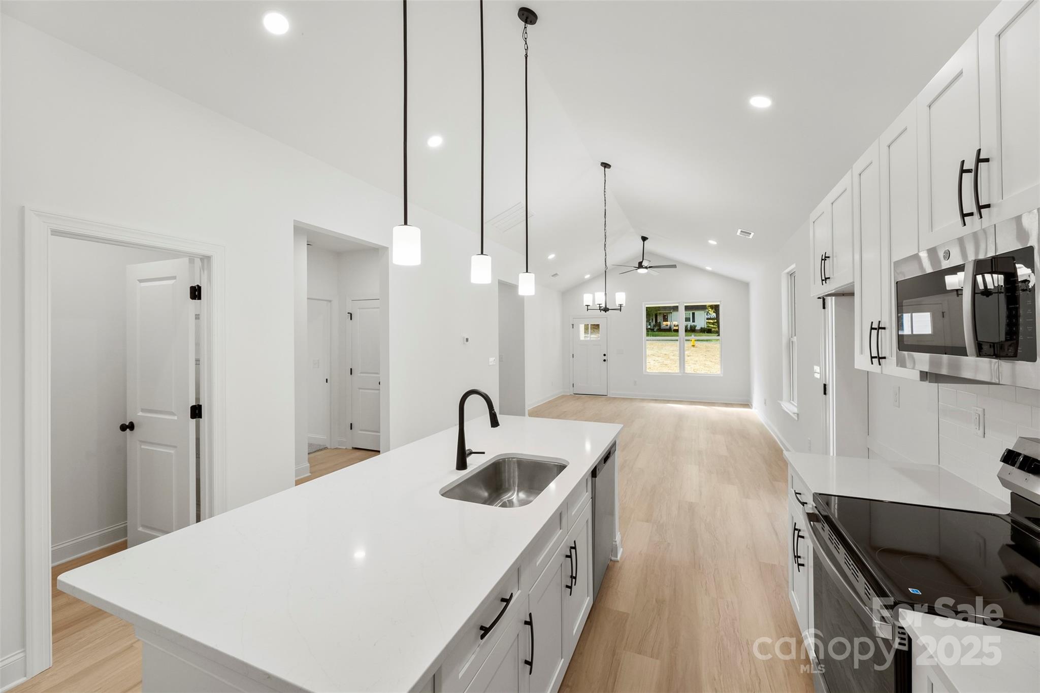 90 Sumner Avenue Northwest Concord, NC 28027 - Photo 3 of 40 a large kitchen with kitchen island a sink appliances and a counter top space