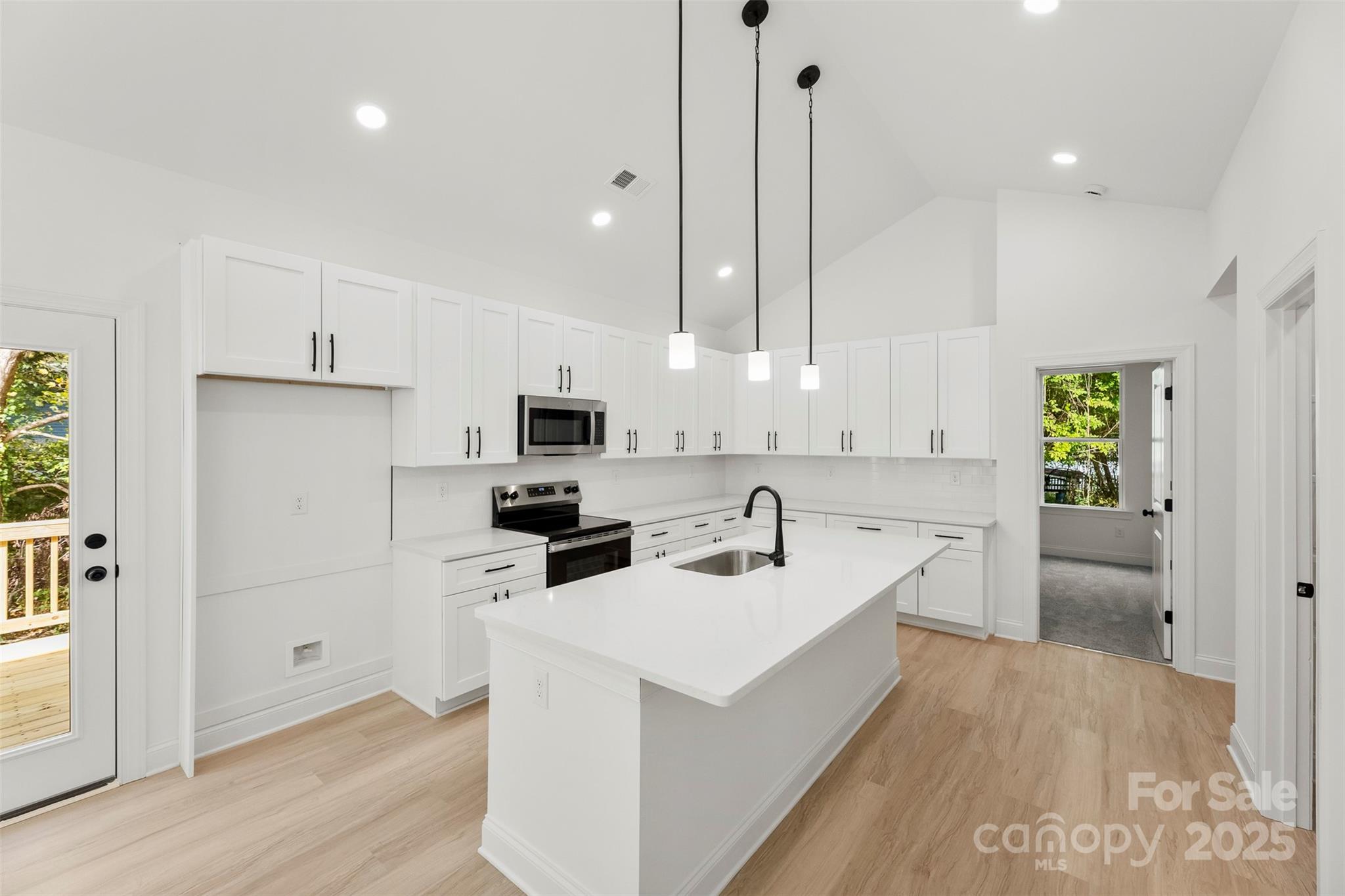 90 Sumner Avenue Northwest Concord, NC 28027 - Photo 4 of 40 a kitchen with a sink a counter top space stainless steel appliances and cabinets