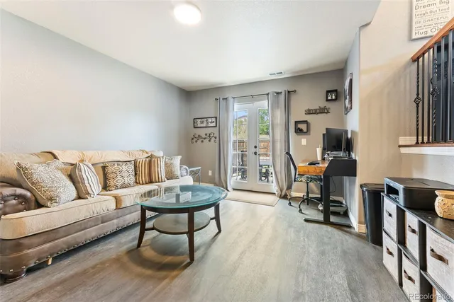 a living room with furniture and a dining table with wooden floor