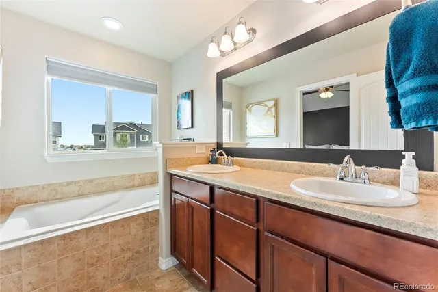 a bathroom with a sink double vanity granite tub and a mirror