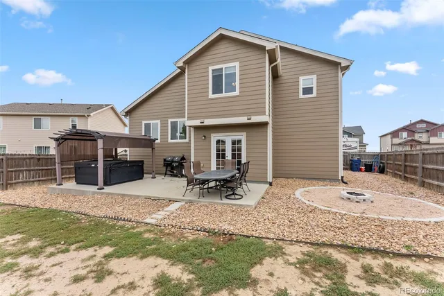 a view of a house with a yard and chairs in patio