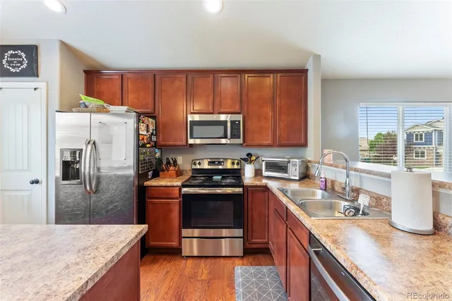 a kitchen with stainless steel appliances granite countertop a refrigerator stove and sink