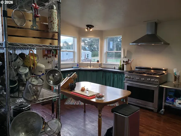 a kitchen with a stove and a wooden floor