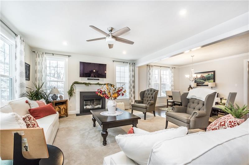 Family room with ceiling fan and gas fireplace. 