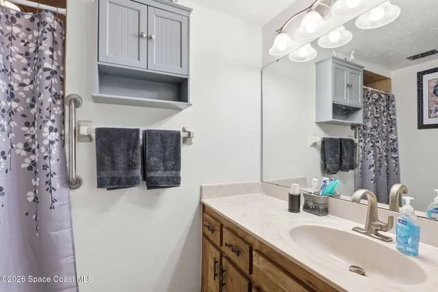 a bathroom with a sink vanity and a mirror