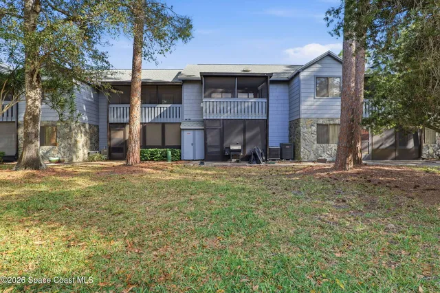 a view of a brick house with a large tree