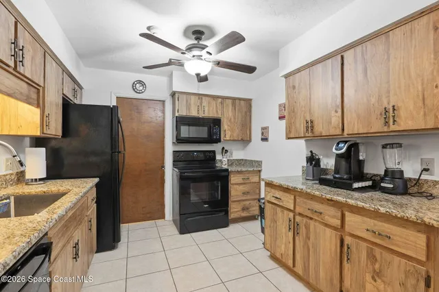 a kitchen with granite countertop a sink stainless steel appliances and cabinets