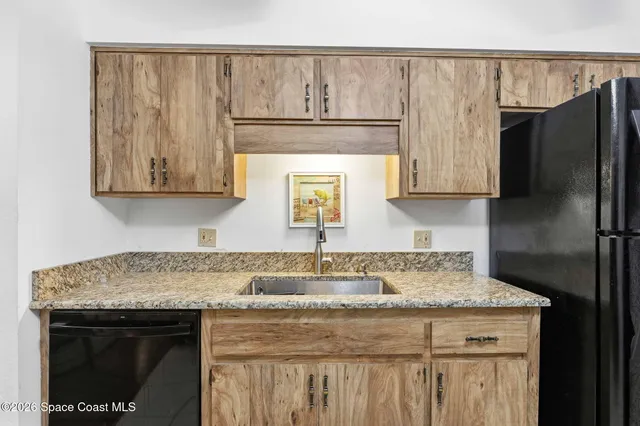 a kitchen with a sink a microwave a refrigerator and cabinets
