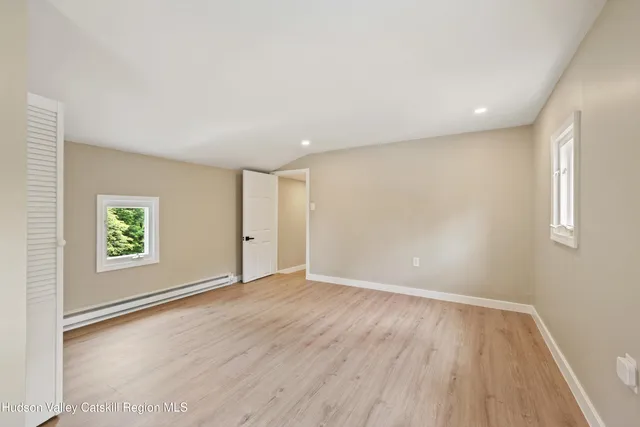 an empty room with wooden floor and window
