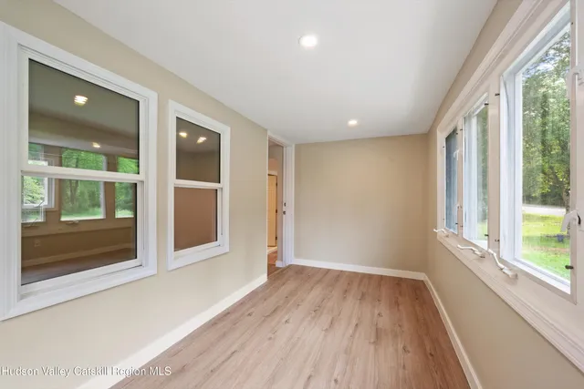 a view of hallway with a large window and wooden floor