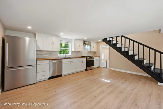 a kitchen with white cabinets and white appliances