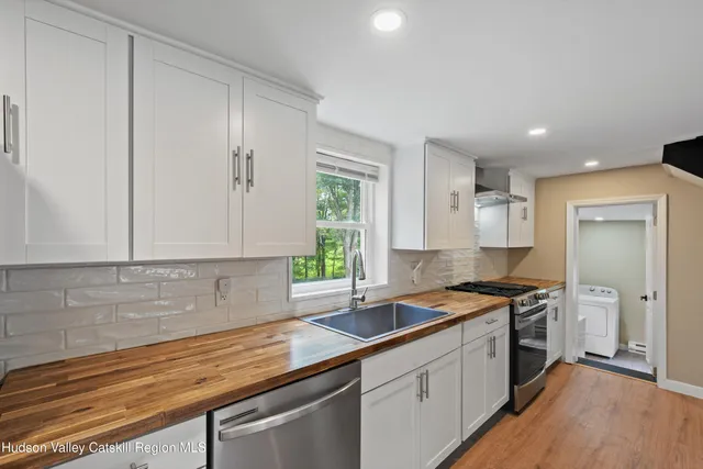 a kitchen with granite countertop a sink a stove and cabinets