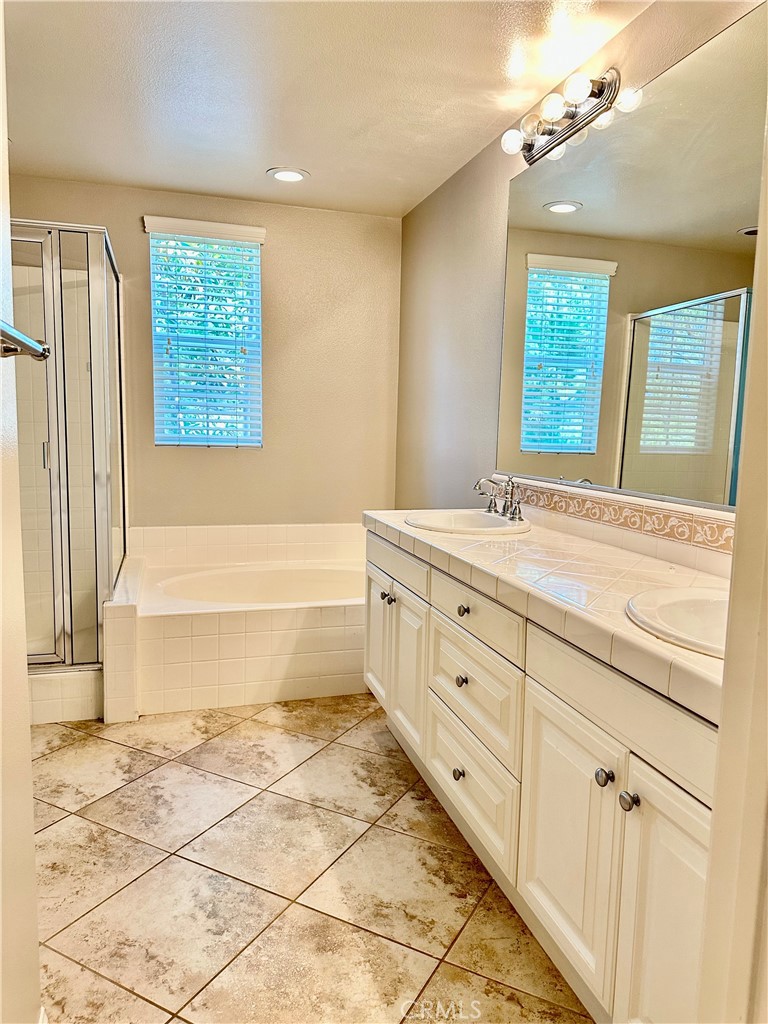 21 Durlston Way Ladera Ranch, CA 92694 - Photo 22 of 47 a bathroom with a double vanity sink a mirror and a bathtub