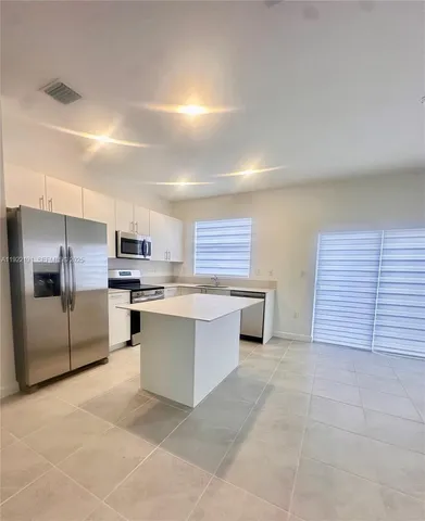 a large kitchen with cabinets and stainless steel appliances