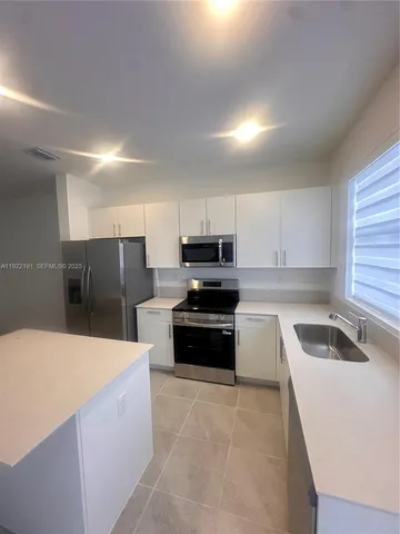 a kitchen with stainless steel appliances wooden cabinets a sink and a stove