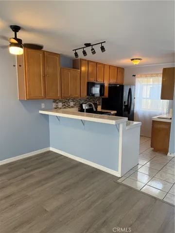 a kitchen with stainless steel appliances a sink cabinets and wooden floor