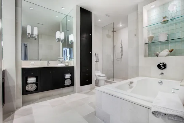 a bathroom with a tub a sink and a large mirror