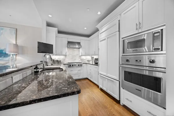 a kitchen with stainless steel appliances granite countertop a stove microwave and cabinets