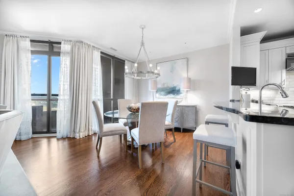a dining room with furniture a chandelier and wooden floor