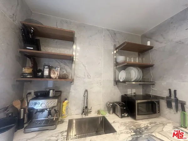 a kitchen with a stove and a wooden floor