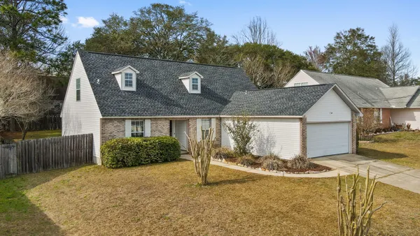a view of a house with backyard and trees