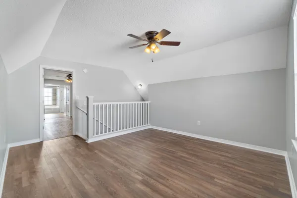 a view of a livingroom with wooden floor and a ceiling fan