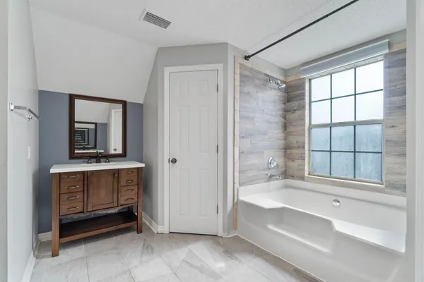 a spacious bathroom with a tub and a sink