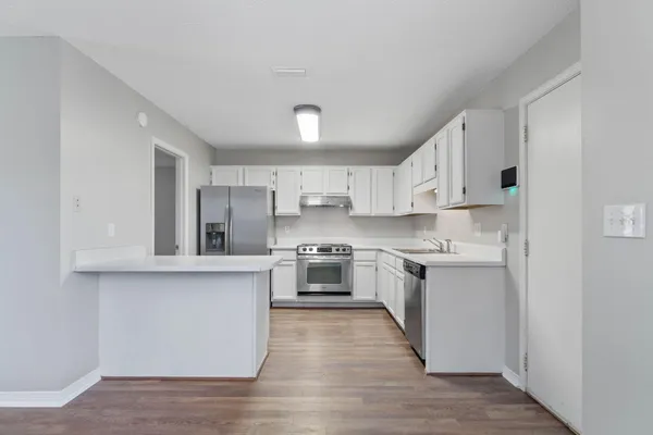 a large kitchen with stainless steel appliances and a sink