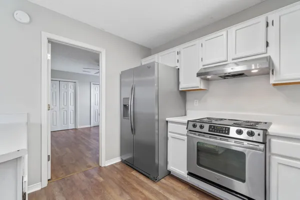 a kitchen with stainless steel appliances granite countertop a stove a refrigerator and cabinets