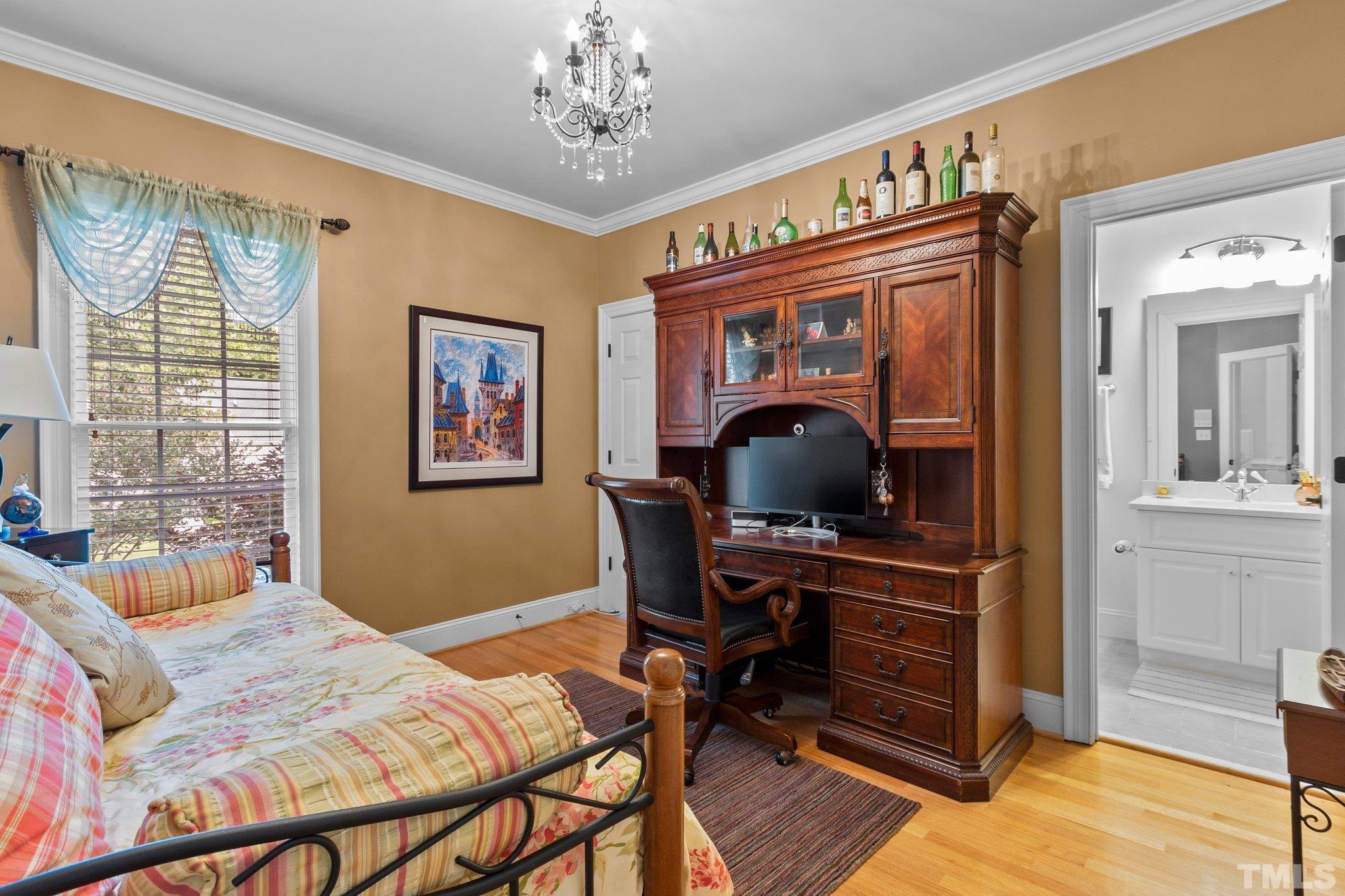 3205 Tall Tree Place Raleigh, NC 27607 - Photo 11 of 58 a bedroom with a bed and a chandelier