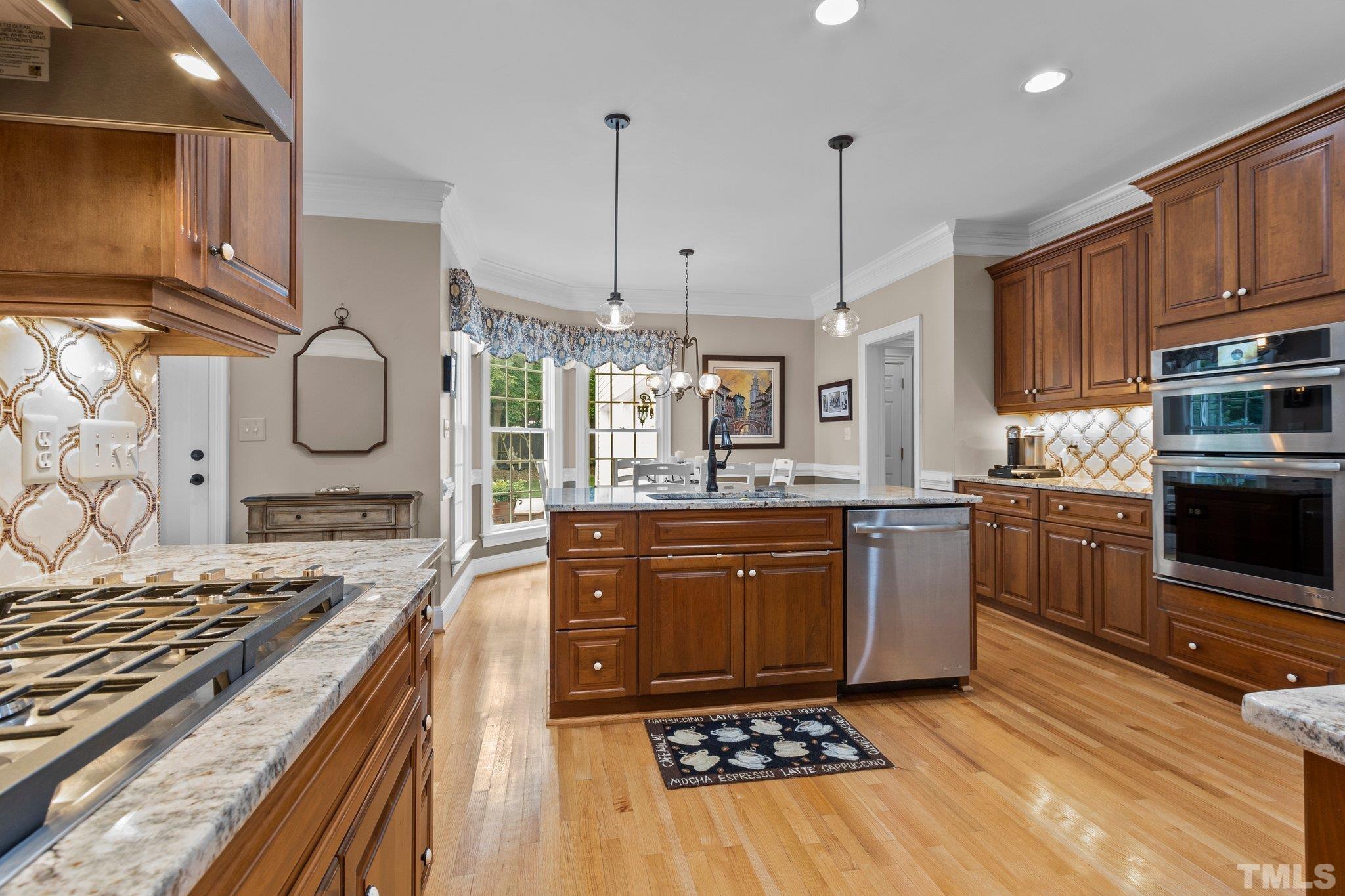 3205 Tall Tree Place Raleigh, NC 27607 - Photo 13 of 58 a kitchen with stainless steel appliances granite countertop a stove a sink and a microwave