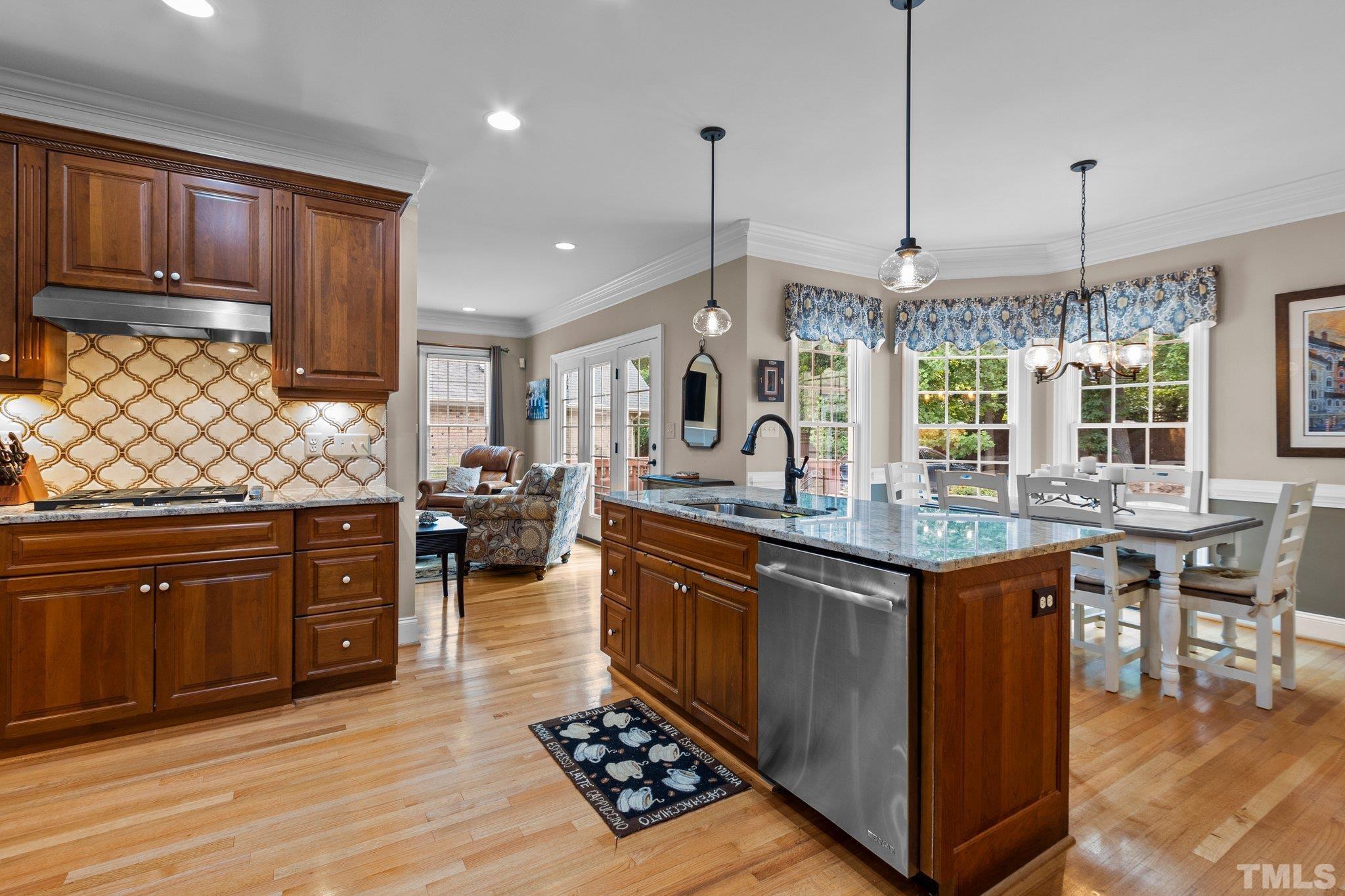3205 Tall Tree Place Raleigh, NC 27607 - Photo 16 of 58 a kitchen with stainless steel appliances granite countertop a stove a sink dishwasher and a wooden cabinets