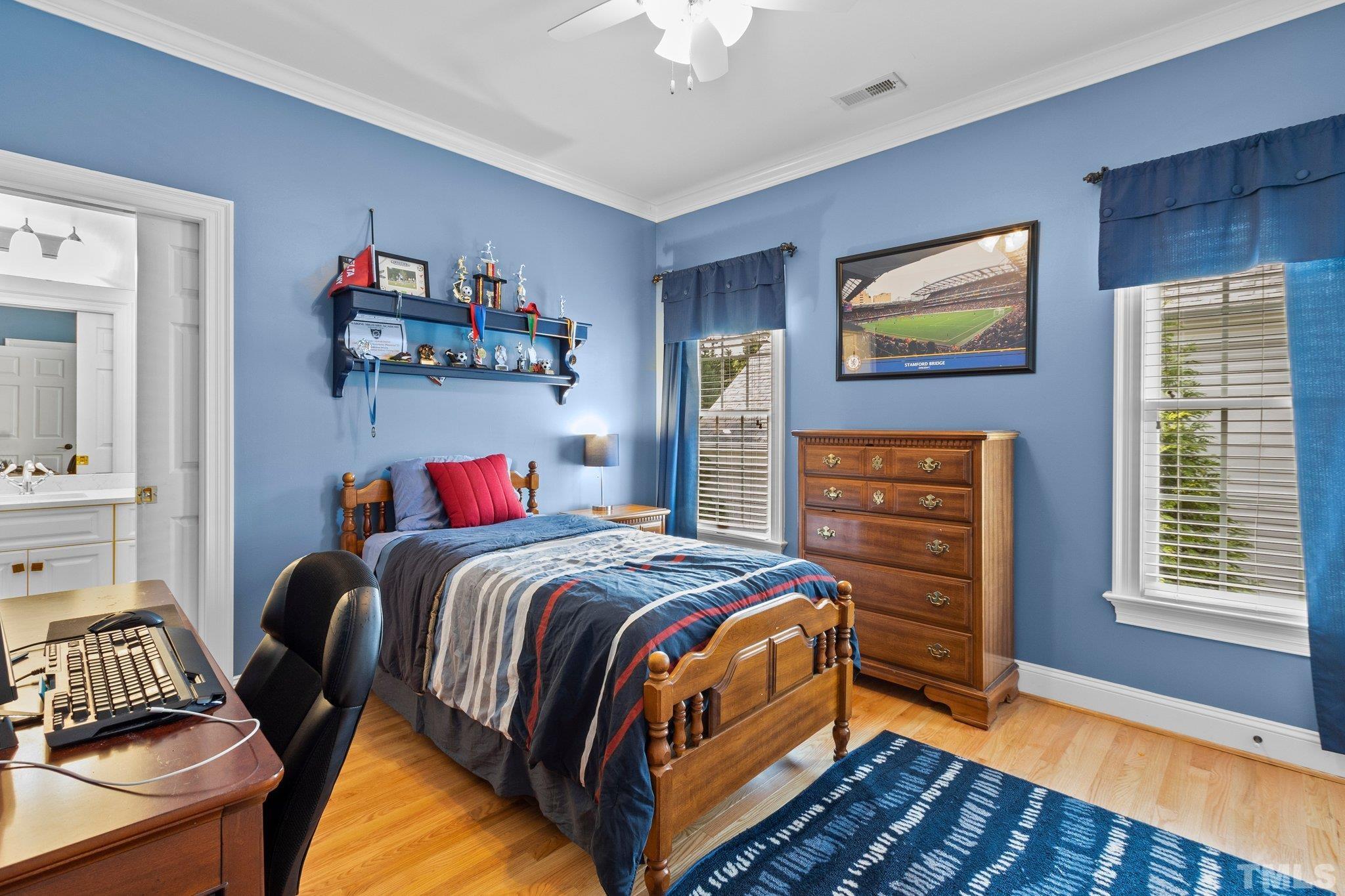 3205 Tall Tree Place Raleigh, NC 27607 - Photo 31 of 58 a bedroom with a bed and a chandelier