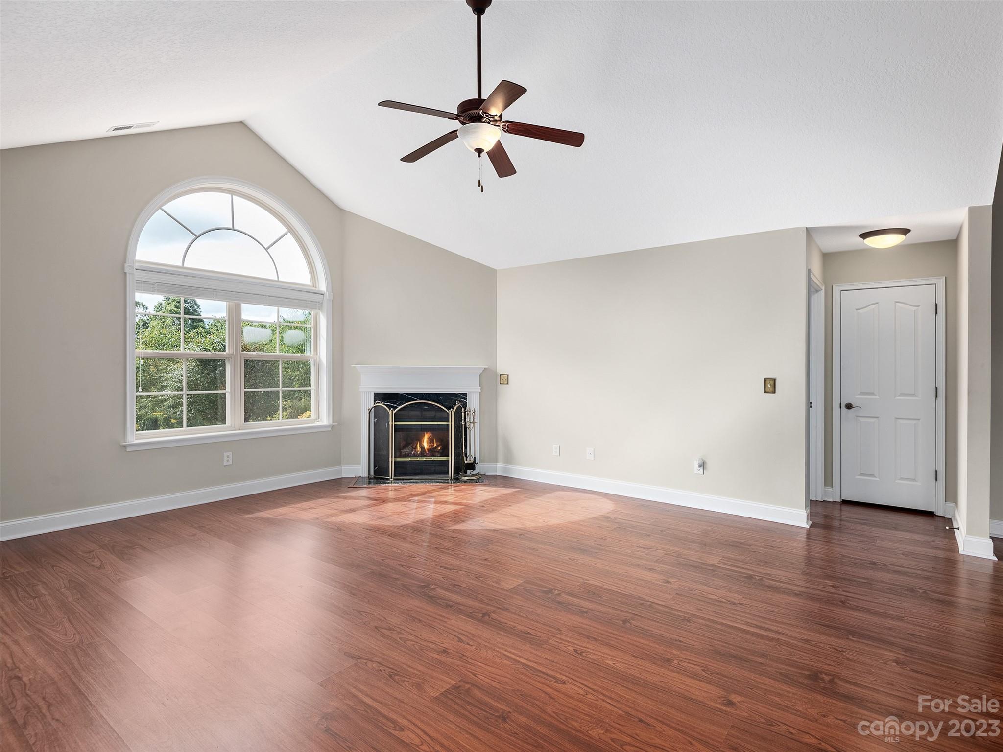 75 Outlook Circle Swannanoa, NC 28778 - Photo 2 of 31 an empty room with wooden floor a ceiling fan and windows