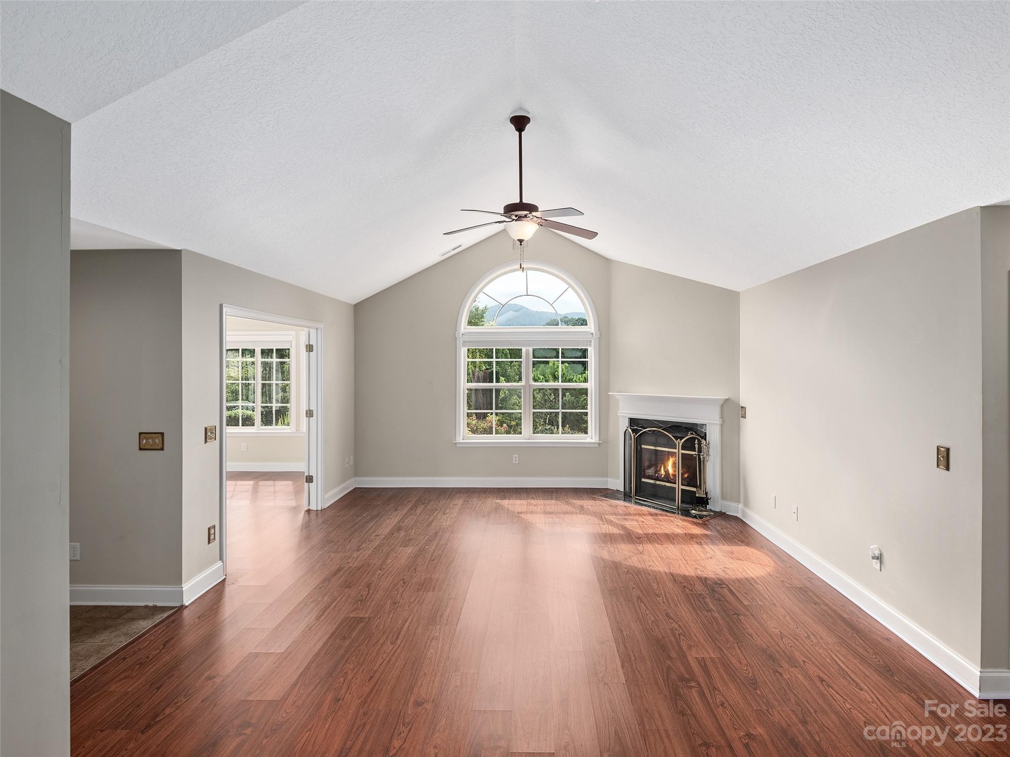 75 Outlook Circle Swannanoa, NC 28778 - Photo 3 of 31 an empty room with wooden floor fireplace and windows