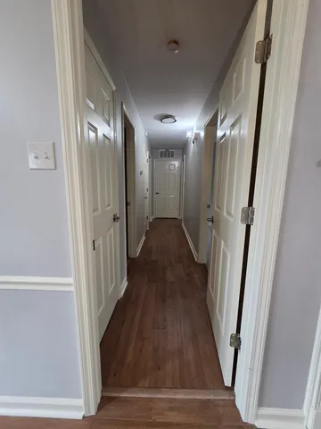 a view of a hallway with wooden floor